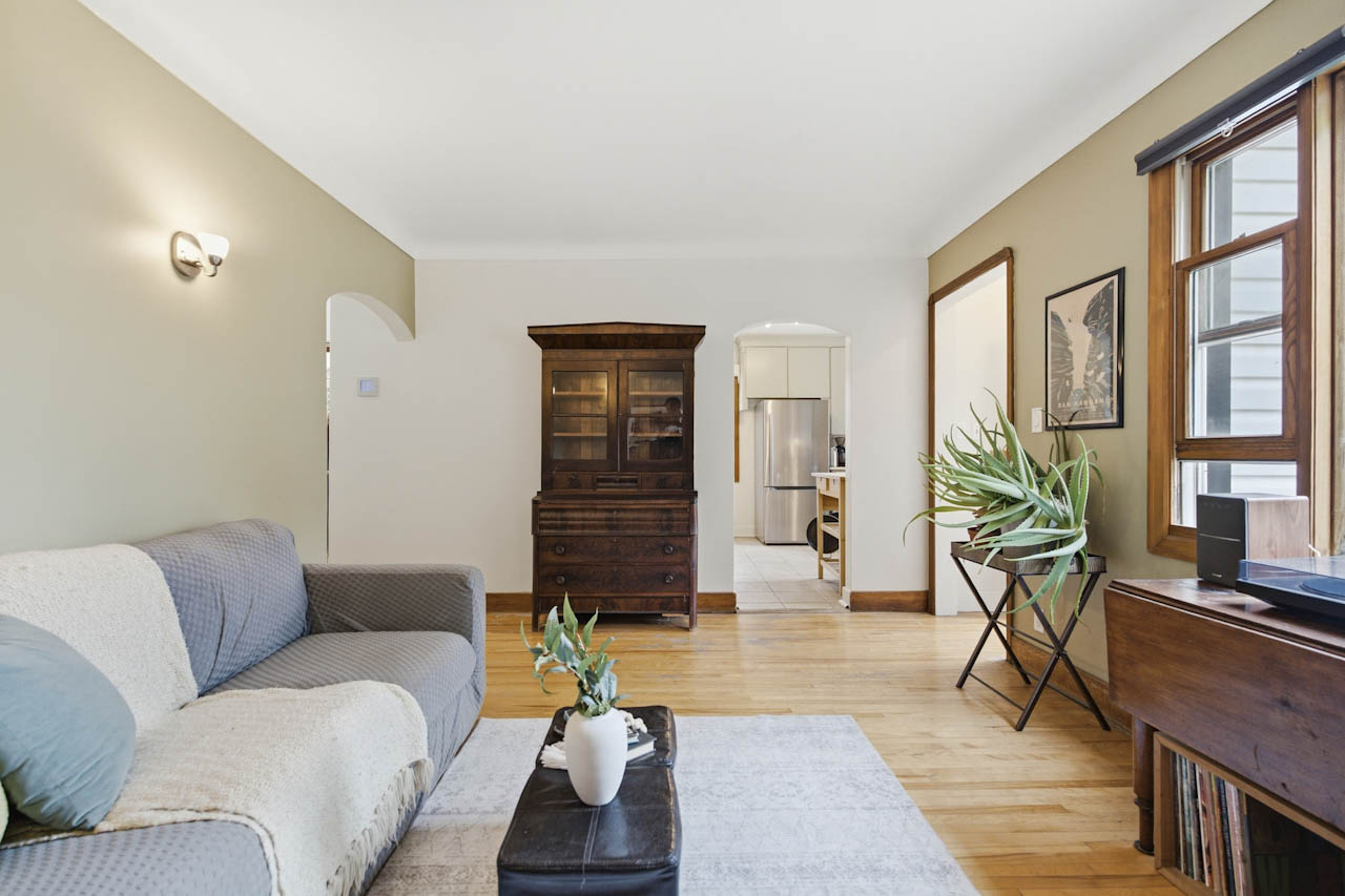 Living room looking toward a wood hutch and the hallway, with hardwood floors