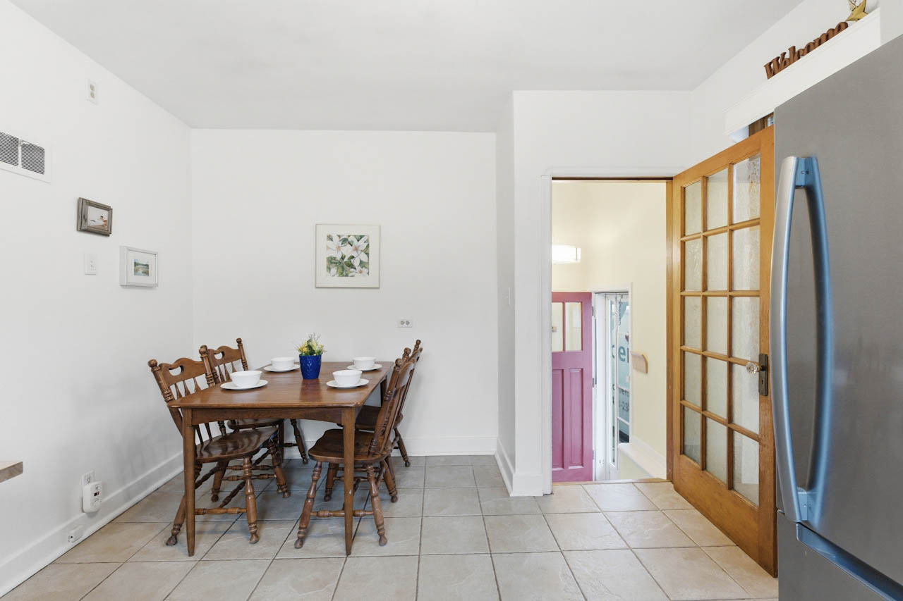 Dining area with wood table and chairs beside the French door and kitchen